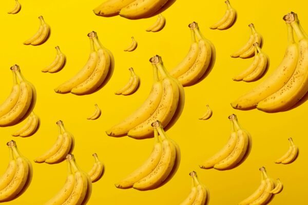 A creative and vibrant pattern of bananas against a bright yellow background, ideal for lively designs.